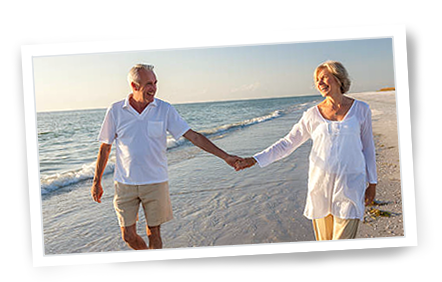 old couple walking down the beach at sunset